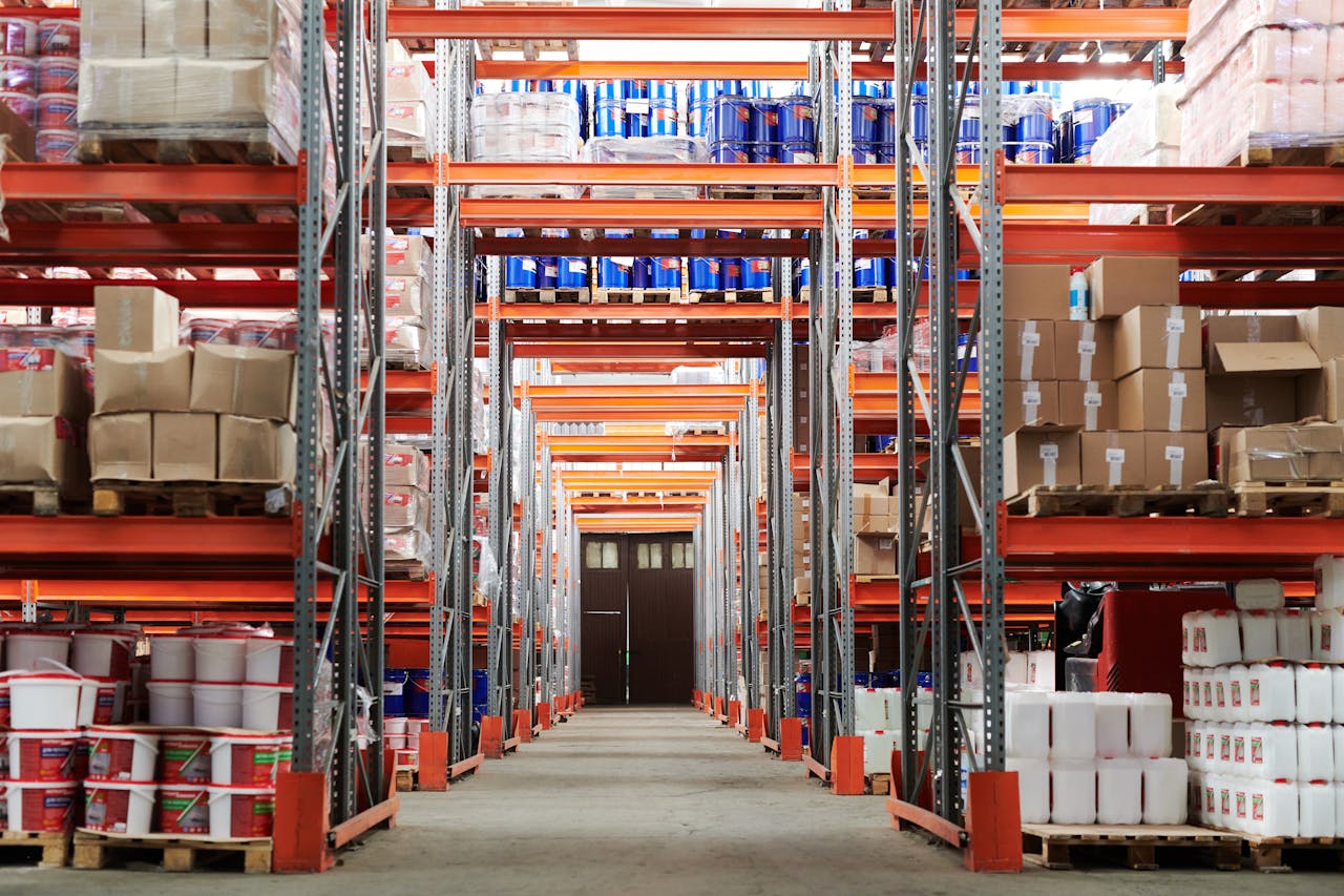 Wide angle view of a warehouse with stocked shelves and boxes.